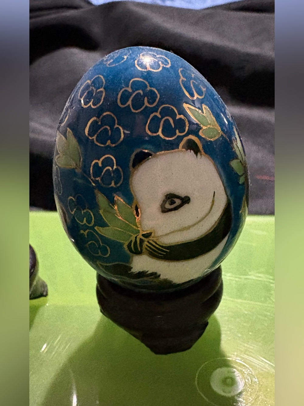hand-painted glass egg from China, featuring a panda bear on a blue background